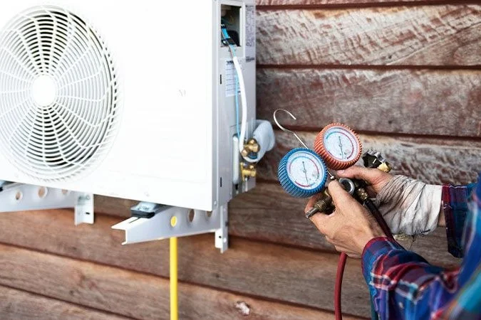 Ricarica del gas: manometri collegati all'unità esterna del climatizzatore